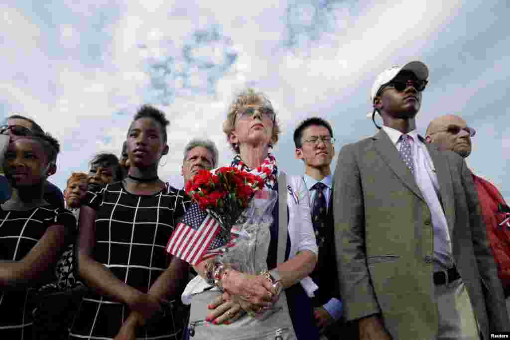 People watch as President Barack Obama, Defense Secretary Ash Carter and Joint Chiefs Chair Gen. Joseph Dunford take part in a ceremony marking the 15th anniversary of the 9/11 attacks at the Pentagon in Washington, Sept. 11, 2016.