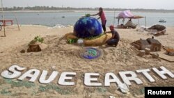 Students make a sand sculpture on the Earth Day, on the banks of the river Yamuna in Allahabad, India, April 22, 2018. REUTERS/Jitendra Prakash - RC1EA881C5B0