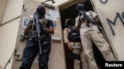 Bodyguards of former senators guard the doorway outside the court house during a hearing following the assassination of President Jovenel Moise, in Port-au-Prince, Haiti, July 12, 2021. 