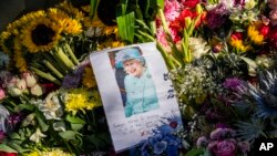 Floral tributes and a farewell message to Queen Elizabeth II are seen outside Holyrood Palace in Edinburgh, Scotland, Sept. 10, 2022.