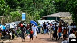 Rohingya refugees gather to buy essentials at a market area in Kutupalong camp a day after cyclone Mocha made landfall, in Ukhia, Bangladesh, May 15, 2023.