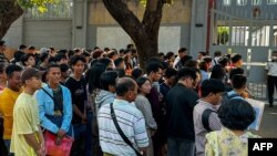 People gather outside the embassy of Thailand to get visas in Yangon on February 16, 2024, after Myanmar's military government said it would impose military service. 