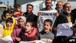 Palestinian men and children gather for a demonstration in Rafah in the southern Gaza Strip on Jan. 30, 2024, calling for continued international support to the United Nations Relief and Works Agency for Palestine Refugees in the Near East (UNRWA).