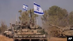 Israeli army vehicles arrive to an staging area after combat in the Gaza Strip in southern Israel, Dec. 30, 2023.