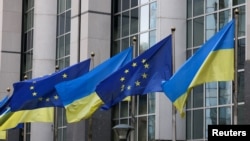 FILE - Flags of Ukraine fly in front of the EU Parliament building on the first anniversary of the Russian invasion, in Brussels, Belgium, Feb. 24, 2023. 