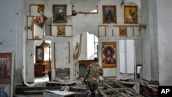 A Ukrainian serviceman prays kneeling in a church damaged in the Russian air raid in the town of Orikhiv, Zaporizhzhia region, Ukraine, April 5, 2024. 