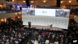 Pictures of the war in Ukraine are seen on a screen at the Munich Security Conference in Munich, Germany, Feb. 17, 2023