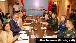 Indian Defense Minister Rajnath Singh, 3rd left, attends a meeting with his Chinese counterpart Li Shangfu, 3rd right, during the Shanghai Cooperation Organization Defense Minister's Meeting in New Delhi, April 27, 2023.