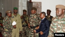 General Abdourahmane Tiani, center, who was declared as the new head of state of Niger by leaders of a coup, arrives to meet with ministers in Niamey, Niger, July 28, 2023. 