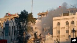 Emergency services work at a destroyed building hit by an airstrike in Damascus, Syria, April 1, 2024. 