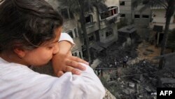 A Palestinian girl looks at the rubble of a building, following an Israeli airstrike, in Beit Lahia in the northern Gaza Strip.