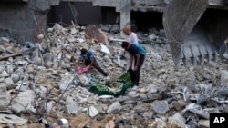 Palestinians recover the bodies of the al Meghari family killed in the Israeli bombardment of the Gaza Strip in Bureij refugee camp, Gaza Strip, Nov. 14, 2023.