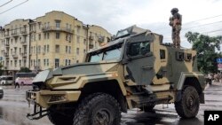 A serviceman stands atop an armored vehicle of the Wagner Group military company, guarding an area at the HQ of the Southern Military District, Rostov-on-Don, Russia, June 24, 2023.