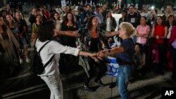 People react as they hear the news of the release of 13 Israeli hostages held by Hamas in the Gaza strip, in Tel Aviv, Israel.