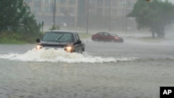 One motorist drives though high water as another turns around during the effects of Hurricane Ian, Sept. 30, 2022, in Charleston, S.C.