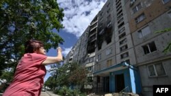 A local resident looks at a heavily damaged residential building in Saltivka, a northern district of the second largest Ukrainian city of Kharkiv on July 31, 2022, amid the Russian invasion of Ukraine. 