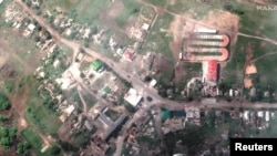 A satellite image shows damaged buildings and a tank on a road, in Lyman, Ukraine May 25, 2022.