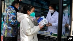 A resident carries away medicine bought at a pharmacy in Beijing, Dec. 9, 2022. 