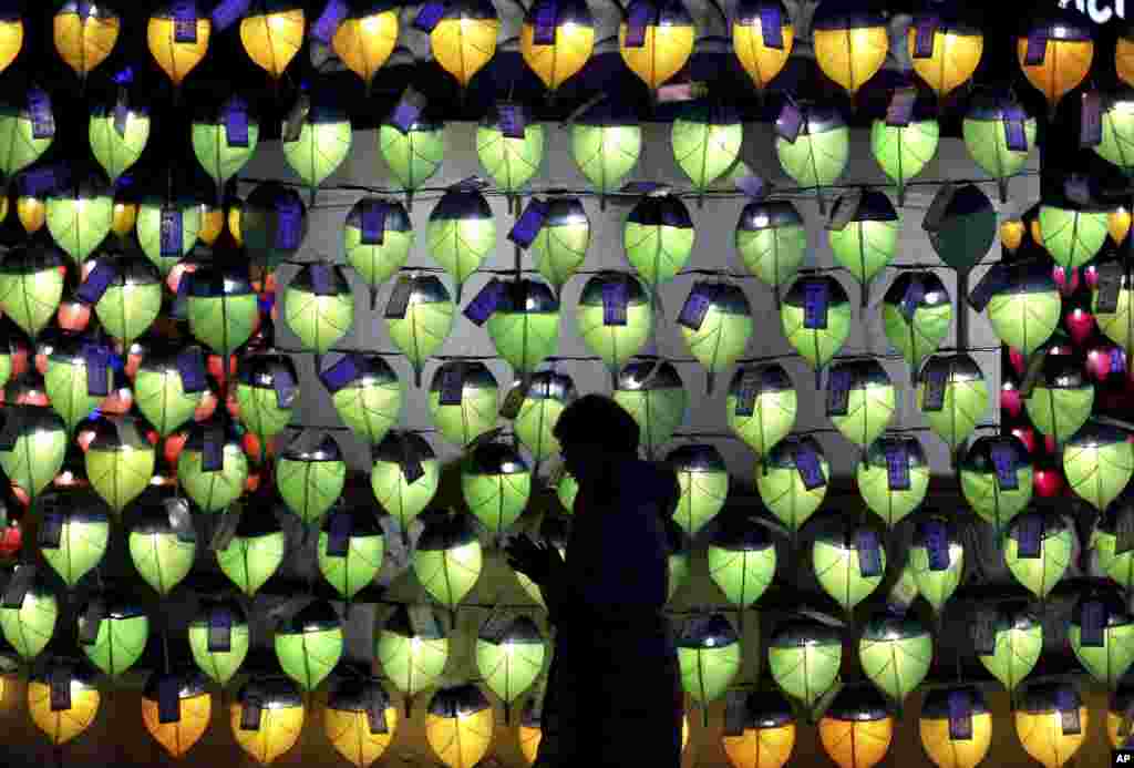 A woman prays in front of lanterns to celebrate the New Year at Jogyesa Buddhist temple in Seoul, South Korea, Dec. 31, 2017.