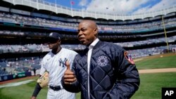 Majistra Vil Nouyok la, Eric Adams kanpe sou gazon an ak yon jwe ekip bezbol New York Yankees ki rele Luis Severino anvan yon match kont Boston, Vandredi 8 Avril 2022 nan Nouyok siti. 