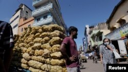 A man stands by a cart with potatoes at a market, amid the country's economic crisis in Colombo, Sri Lanka, April 7, 2022.