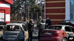 Ukrainian servicemen stand next to damaged cars after Russian shelling at the railway station in Kramatorsk, Ukraine, April 8, 2022.