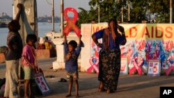 Street children play with red ribbon left on display by activists on the banks of the Hooghly River ahead of World AIDS Day in Kolkata, India, Nov. 30, 2022.