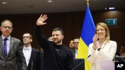 Ukraine's President Volodymyr Zelenskyy, center, gestures as European Parliament's President Roberta Metsola, right, applauds during an EU summit at the European Parliament in Brussels, Belgium, Feb. 9, 2023.