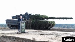 FILE - German Chancellor Olaf Scholz delivers a speech in front of a Leopard 2 tank during a visit to a military base of the German army Bundeswehr in Bergen, Oct. 17, 2022.