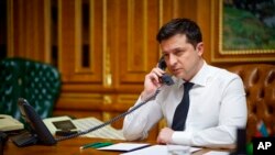 FILE - Ukrainian President Volodymyr Zelenskyy speaks with U.S. President Joe Biden by phone in his office in Kyiv, Ukraine, Dec. 9, 2021. The two spoke again on March 11, 2022, with Biden providing an update on efforts to raise the cost of war for Russia (ယခင်မှတ်တမ်းဓါတ်ပုံ)