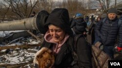 A woman cries as she escapes Irpin, Ukraine, March 8, 2022. (Yan Boechat/VOA) 