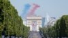 French elite acrobatic flying team "Patrouille de France" (PAF) release smoke in the colours of the French flag as they perform a fly-over during the Bastille Day military parade on the Champs-Elysees avenue in Paris, July 14, 2022. 