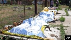 Investigators examine bodies of Ukrainian military prisoners at a prison in Olenivka, in an area controlled by Russian-backed separatist forces, eastern Ukraine, July 29, 2022.