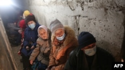 FILE - Residents of Sievierodonetsk, Lugansk Oblast, wait hidden in their basement during the heavy shelling by Russian forces and Russia-backed separatists, Feb. 28, 2022.