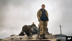 A Ukrainian soldier stands on a tank on the road in the freed territory of the Kharkiv region, Ukraine, Sept. 12, 2022. 