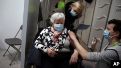 A woman receives a dose of the AstraZeneca COVID-19 vaccine at the Vaccine Village in Antwerp, Belgium on Tuesday, March 16, 2021. Belgium on Tuesday reaffirmed its support to AstraZeneca vaccines and said it will keep using it in its current…