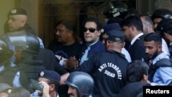 Security officers escort Pakistan's former Prime Minister Imran Khan as he appeared in Islamabad High Court