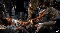 Police officers try to detain students and activists during a protest demonstration against a new short-term government recruitment scheme for the military, in New Delhi, India, June 17, 2022.