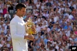 Sèrb Novak Djokovic kenbe twofe li pandan li selebre viktwa li sou Ostralyen Nick Kyrgioso nan chanpyona tenis Wimbledon nan, Dimanch 10 Jiye, 2022.