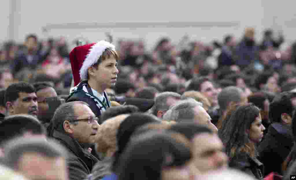 A boy listens to Pope Francis delivering his &quot;Urbi et Orbi&quot; (to the City and to the World) message in St. Peter&#39;s Square at the Vatican, Dec. 25, 2014.