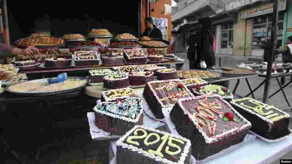 New Year's cakes are displayed outside a shop in Sheikh Maksoud neighborhood of Aleppo, Syria, Dec. 31, 2014. 