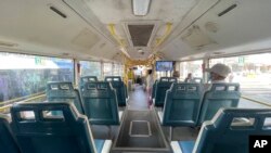 Few commuters ride on a mostly empty bus in Yangon.