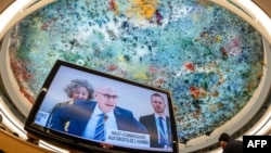 UN High Commissioner for Human Rights Volker Turk is seen on a TV monitor as the ceiling of the Human Rights and Alliance of Civilizations Room, painted by Spanish painter Miquel Barcelo, is seen in the background at the opening of the 53rd UN Human Righ