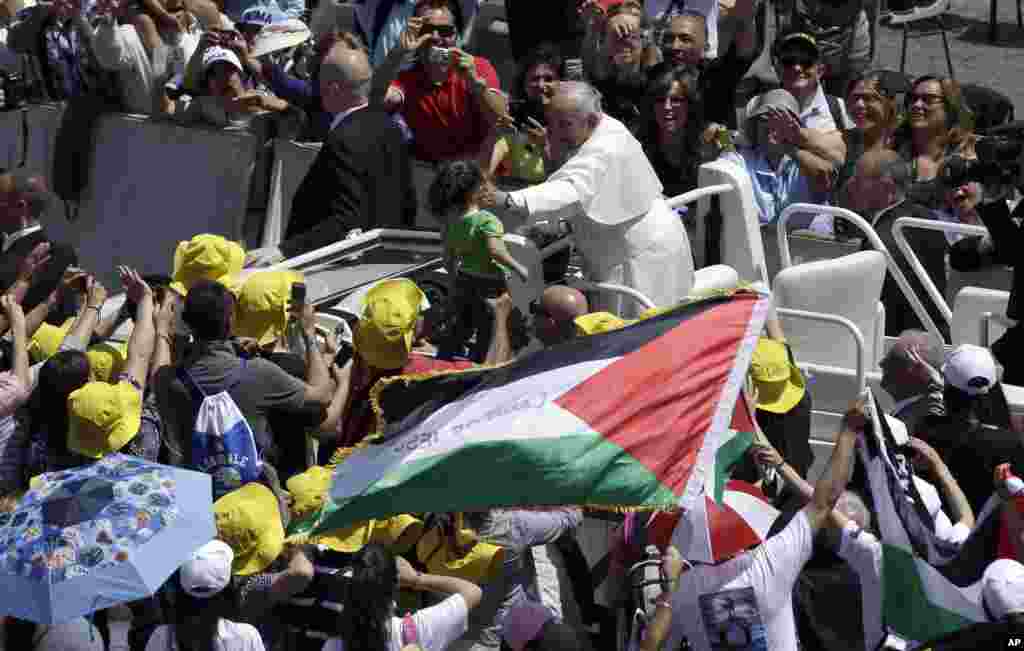 Pope Francis greets a child in St. Peter&#39;s Square at the Vatican, May 17, 2015.