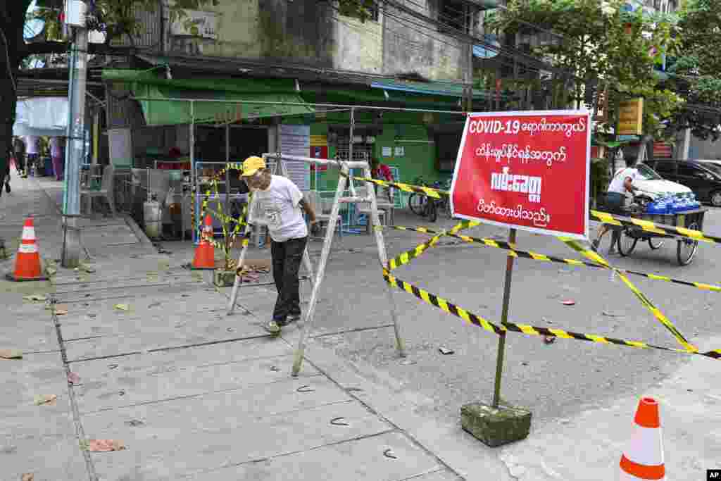 ကိုရိုနာဗိုင်းရပ်စ် ကူးစက်ပျံ့နှံ့မှု တိုးနေတဲ့ ရန်ကုန်မြို့မှာ အဝင်အထွက် ကန့်သတ်ပိတ်ဆို့ထားတဲ့ လမ်းတခုအနီး ဖြတ်သွားတဲ့ ဒေသခံတဦး။ (စက်တင်ဘာ ၁၁၊ ၂၀၂၀)