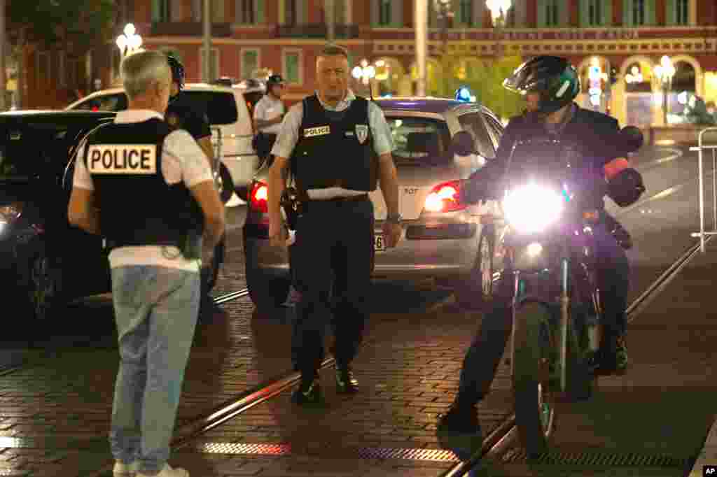 Police officers seal off the area of an attack after a vehicle drove onto the sidewalk and plowed through a crowd of revelers who'd gathered to watch Bastille Day fireworks in the French resort city of Nice, July 15, 2016.