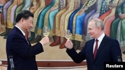 FILE PHOTO: Russian President Vladimir Putin and Chinese President Xi Jinping attend a reception in Moscow