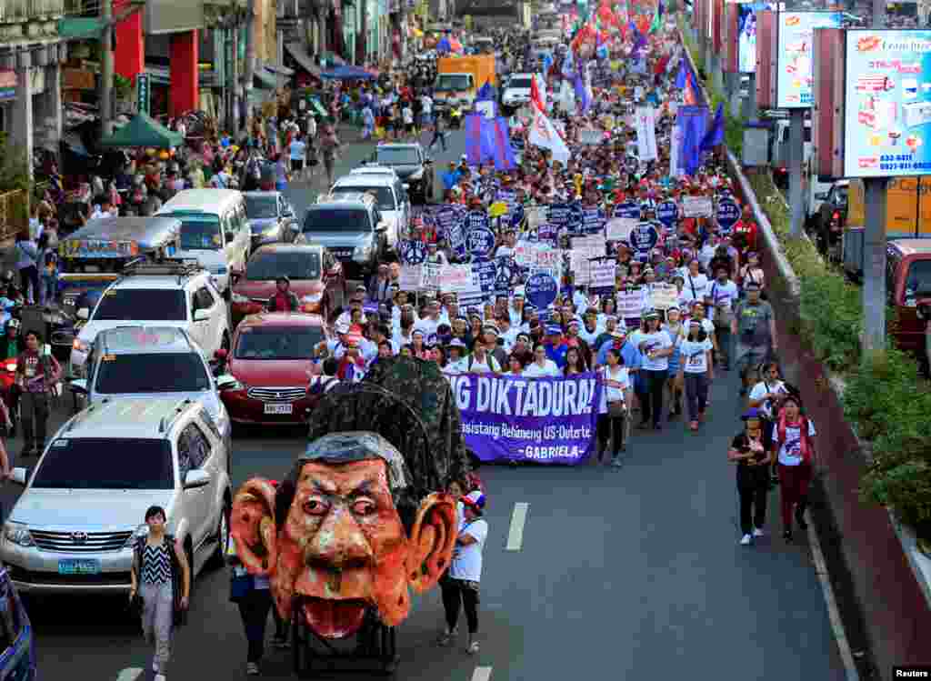 An effigy of Philippine President Rodrigo Duterte is seen while women's rights activists march along a busy street during a celebration of the International Women's Day in Quiapo city, Metro Manila, Philippines, March 8, 2018. 