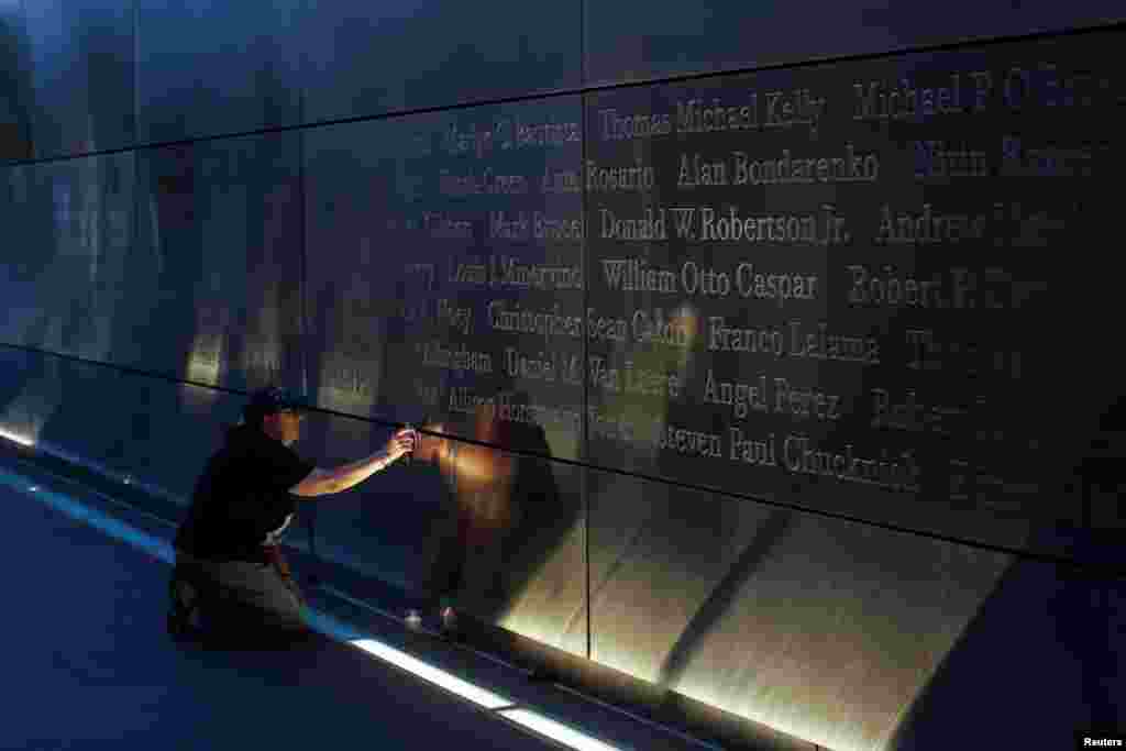 A mourner places a flag in the Empty Sky memorial on the morning of the 15th anniversary of the 9/11 attacks in New Jersey, Sept. 11, 2016.