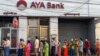 People wait for a branch of the AYA Bank to open, ahead of a long holiday stretch for the Myanmar New Year, also known as Thingyan, in Yangon on April 12, 2021, as the country remains in turmoil after the February military coup. (Photo by STR / AFP)